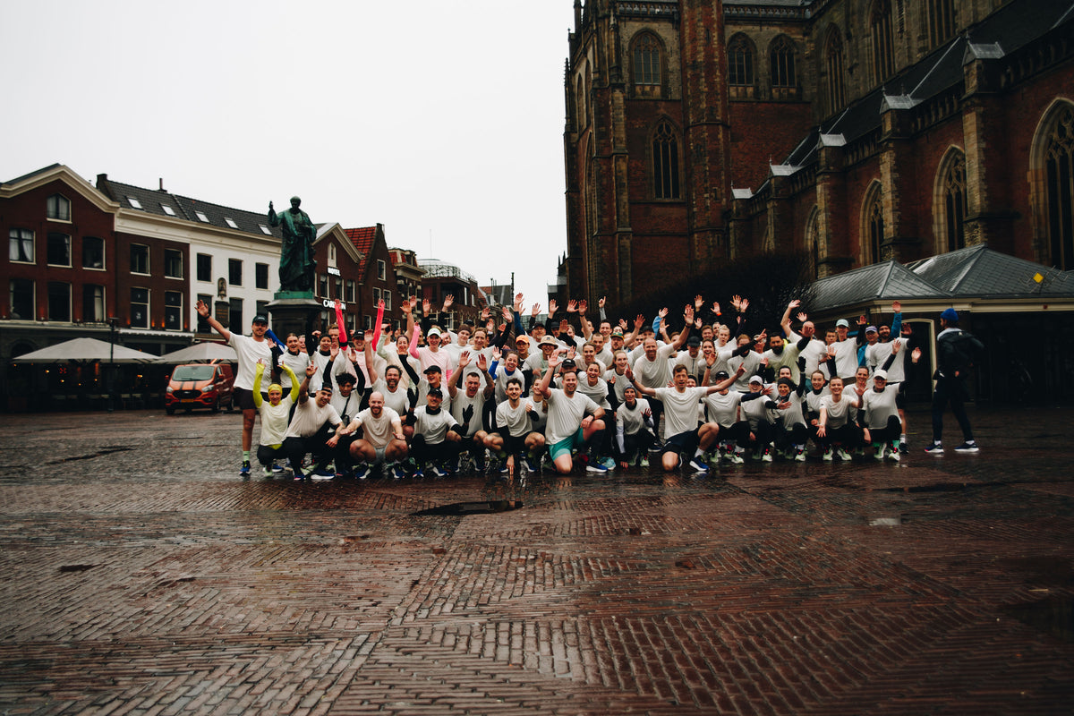 Groepsfoto van New Glory X DailyRun en Salomon op de Grote Markt in Haarlem