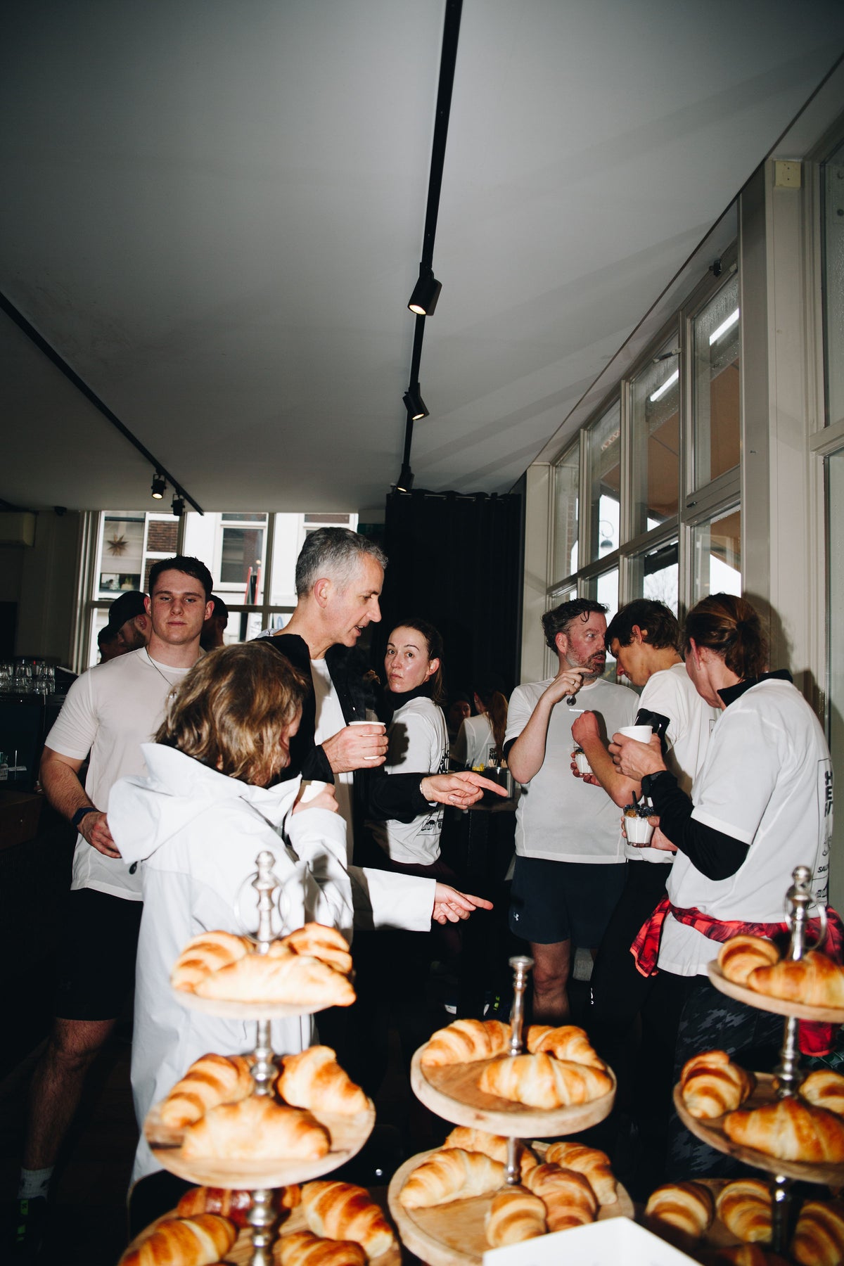 Deelnemers met koffie en croissants na New Glory X DailyRun en Salomon