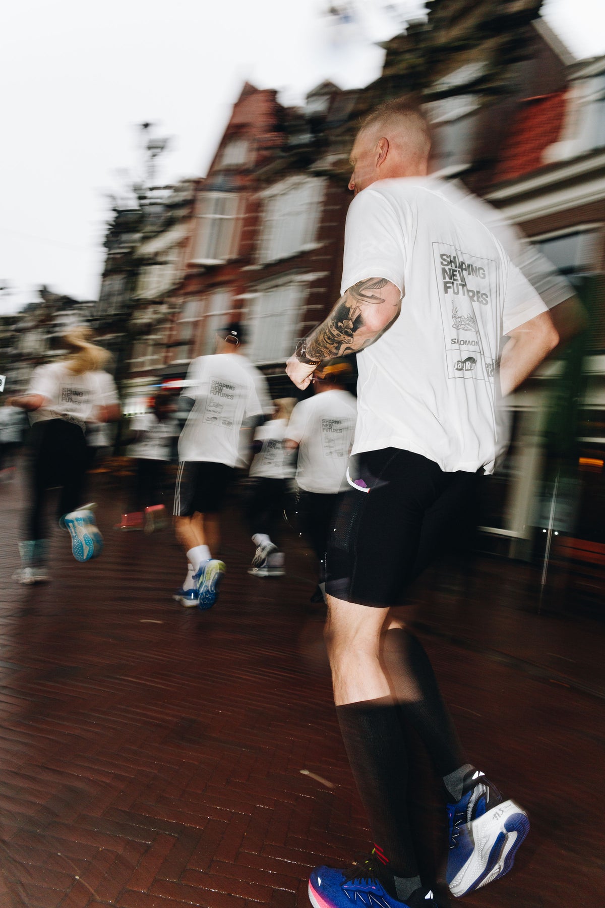 Lopers in New Glory en Salomon shirts door Haarlem